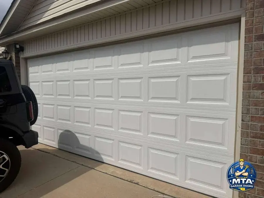 Finished white sectional garage door viewed from inside a garage